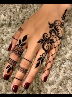 a woman's hand with henna tattoos on it