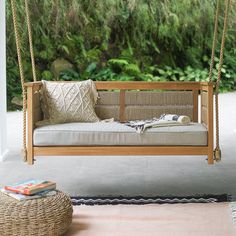 a porch swing with pillows on it