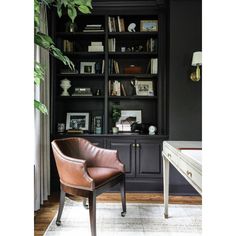 a leather chair sitting in front of a book shelf