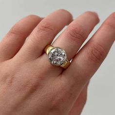 a woman's hand with a gold and diamond ring on top of her finger