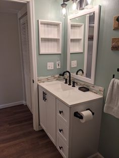 a white bathroom sink sitting under a mirror