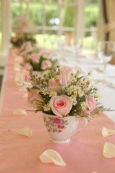 a long table with pink and white flowers on it