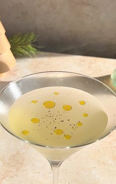 a martini glass with yellow dots in it on a table next to an orange and green donut