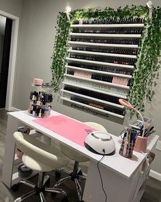 a nail salon with manicures and plants on the wall next to it's desk