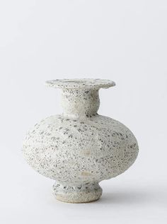 a white vase sitting on top of a table