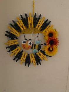 a clock made out of legos and sunflowers on a white wall next to a door