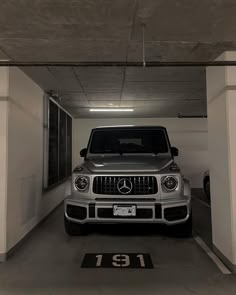 a mercedes benz is parked in an empty parking garage with the door open to let people know where they are going