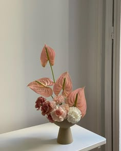 an arrangement of flowers in a vase on a table