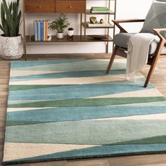 a living room area with a chair, rug and bookshelf on the floor