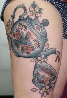 a woman's thigh with a teapot and flowers on it