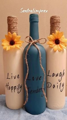 three wine bottles with flowers on them sitting on a table next to each other and the words live, love, laugh, friendly