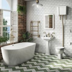 a bathroom with green and white tiles on the floor, tub, toilet and sink