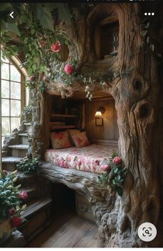 a bed made out of tree trunks with flowers on it and stairs leading up to the top