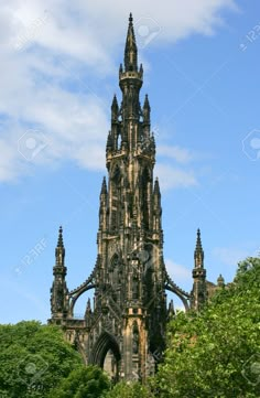 a tall building with many spires surrounded by trees