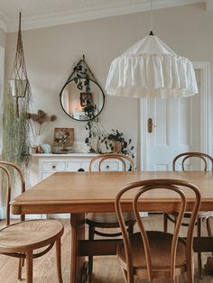 a dining room table with four chairs and an umbrella hanging from the ceiling over it