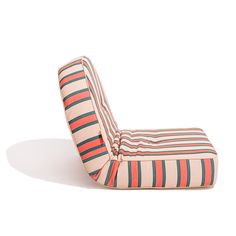 an upholstered chair that is made out of fabric and has stripes on it