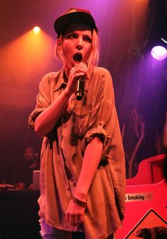 a woman singing into a microphone on stage