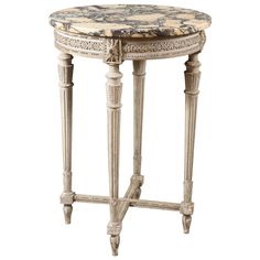 an ornately decorated table with marble top and wooden legs, against a white background