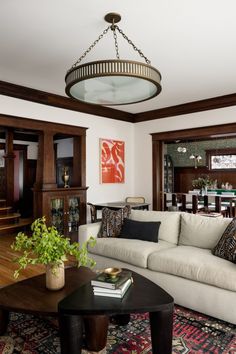 a living room filled with furniture and a chandelier hanging over the top of it