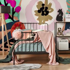 a child's bedroom with pink and green wallpaper, black iron bed frame, white rugs and wooden flooring