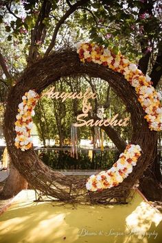 a wreath with flowers and the words happily married is displayed in front of a tree