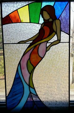 a stained glass window with a woman's body in the center and colors behind it