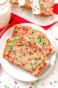 two slices of christmas sprinkle cake on white plates with red and green napkins