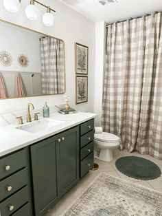 a bathroom with two sinks and a rug in front of the shower curtain that is open