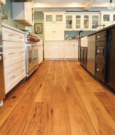 a kitchen with wood floors and white cabinets