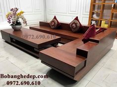 a wooden couch sitting on top of a tiled floor next to a vase with flowers