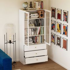 a white book shelf with books on it in a living room next to a blue couch