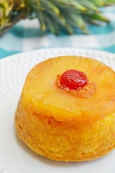 a pineapple upside down cake sitting on a white plate next to a pineapple