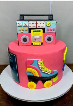 a pink cake with roller skates and radio on top