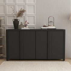 the sideboard is black and has three doors on it, along with two vases