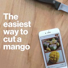 a cell phone sitting on top of a wooden table next to a knife and cutting board