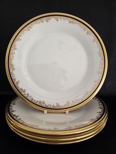 two white and gold plates sitting on top of each other