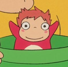 a cartoon character with red hair is holding a green object in front of his face