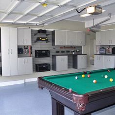 a pool table is in the middle of a large room with white cabinets and appliances