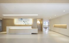 a large white reception area in an office building with modern lighting and artwork on the wall