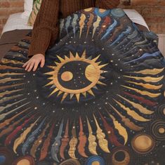 a woman sitting on top of a bed with a blanket covering her face and hand