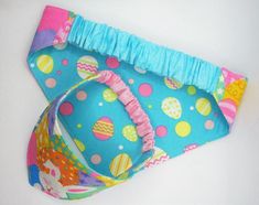 two baby diapers are laying next to each other on a white surface, one has a blue and pink polka dot design