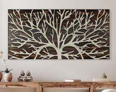 a wooden wall hanging above a table with vases on it