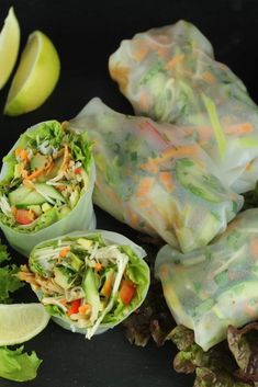 there are several rolls that have vegetables in them and lettuce on the side