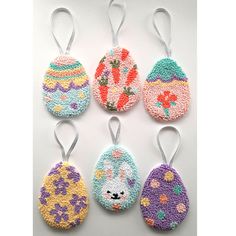 six crocheted easter egg ornaments are shown in different colors and sizes, each decorated with an animal's face