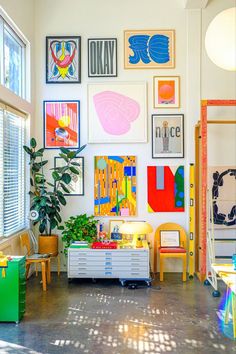 a living room filled with lots of art on the wall and furniture in front of it