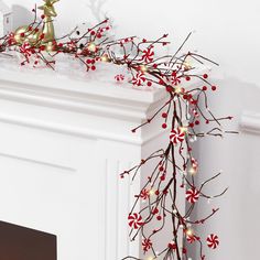 a christmas garland with red and white candy canes hanging from it's side