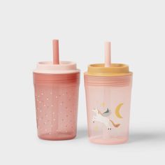 two sippy cups with straws on the top and one has a unicorn design