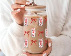 a woman is holding a jar with some candy on it and the lid has red bows