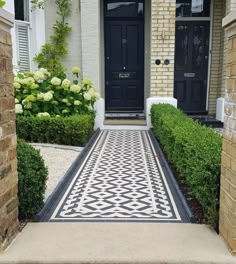 a black and white tiled walkway in front of a house