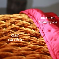 two red rose mulberry silk pillows are shown side by side on a bed